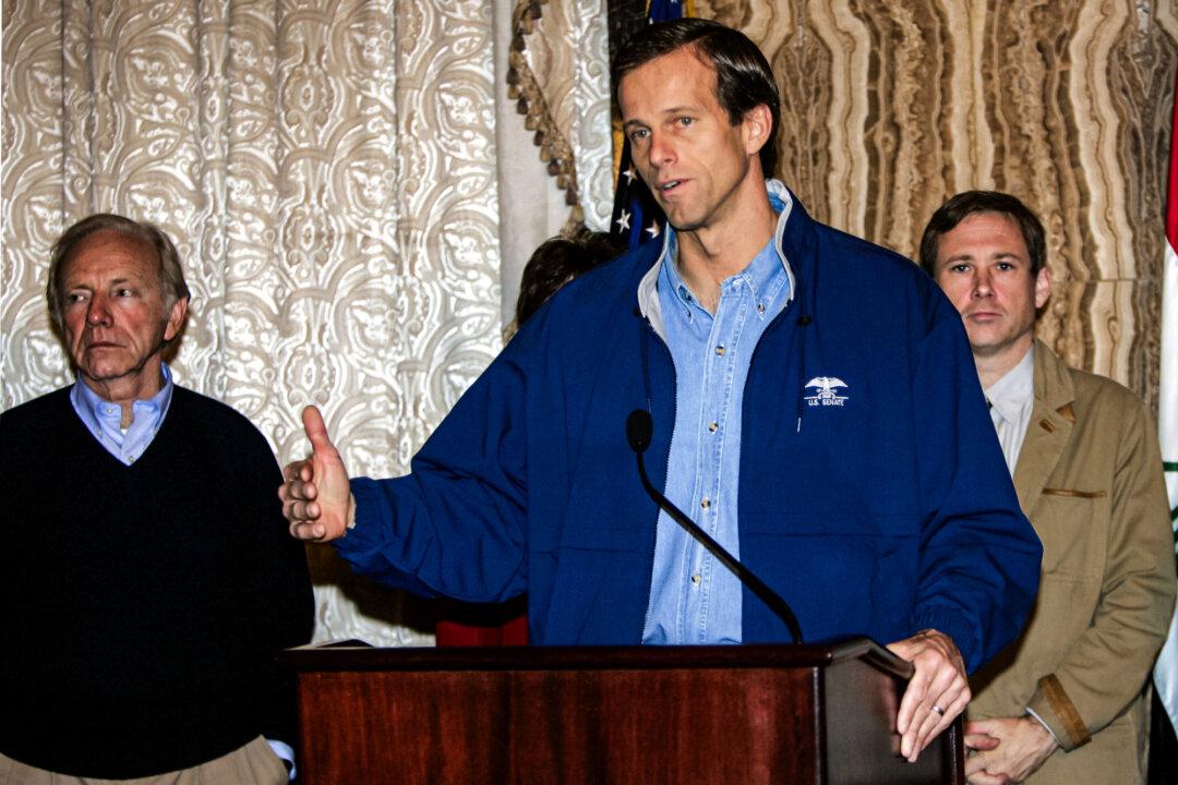 Sen. John Thune (R-S.D.), flanked by Sen. Joseph Lieberman (I-Conn.) and Sen. Mark Kirk (R–Ill.), speaks during a press conference in Baghdad, Iraq, on Dec. 14, 2006. (Sabah Arar/AFP via Getty Images)