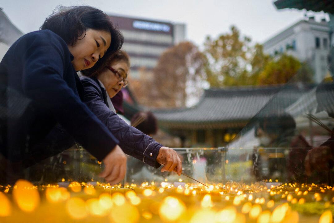 People light candles at the Jogyesa Buddhist temple, where prayers are taking place for students who are sitting for the annual College Scholastic Ability Test, known locally as Suneung, in Seoul, South Korea, on Nov. 14, 2024. (Anthony Wallace/AFP via Getty Images)