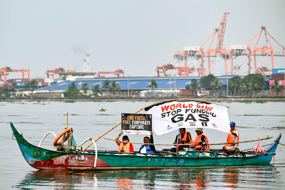 An environmental group onboard a wooden boat stage a demonstration along Manila Bay in Baseco, Manila on Nov. 14, 2024, to mark the Philippines' participation in the Global Days of Action Against Gas Expansion. (Jam Sta Rosa/AFP via Getty Images)