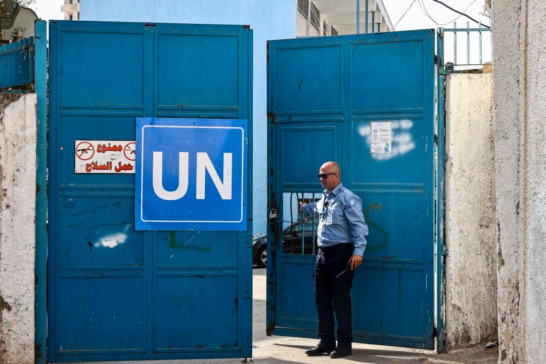 A security guard opens the gate at a United Nations Relief and Works Agency for Palestine Refugees (UNRWA) run school in the Qalandia refugee camp in the West Bank on Nov. 14, 2024. (Zain Jaafar/AFP via Getty Images)