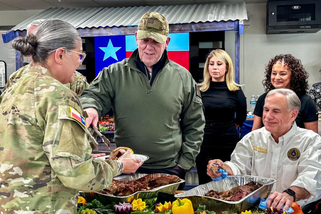 Incoming border czar Tom Homan (C) and Texas Gov. Greg Abbott (R) serve food to Texas personnel deployed to the southern border, in Eagle Pass, Texas, on Nov. 26, 2024. (Darlene McCormick Sanchez/The Epoch Times)