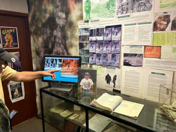 Michael Rugg points to photos of a supposed Bigfoot sighting displayed in the Bigfoot Discovery Museum in Felton, Calif., on Dec. 8, 2024. (Steve Ispas/The Epoch Times)