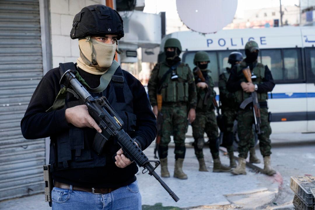 An officer from the Palestinian Authority clutches his gun as Palestinian security forces mount a major raid against militants in the Jenin refugee camp in the West Bank on Dec. 16, 2024. (Majdi Mohammed/AP Photo)