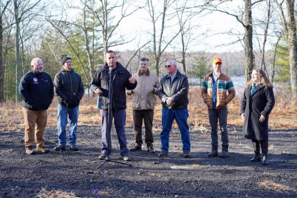 Orange County Executive Steve Neuhaus speaks in front of Boehmler Pond, along with (L to R) Orange County Legislator Tom Faggione, Port Jervis Outdoor Club President Mike Ward, Orange County Land Trust Executive Director Jim Delaune, Deerpark Supervisor Gary Spears, Open Space Institute representative Matt Decker, and Port Jervis community development director Valerie Maginsky in the town of Deerpark, N.Y., on Dec. 18, 2024. (Cara Ding/The Epoch Times)