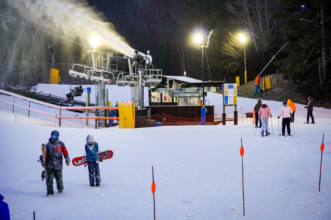 Atlanta residents Derek Worthington and his son Ryder (bottom left) walk back to the lodge after a day of snowboarding at Cataloochee Ski Area on Dec. 11, 2024. (T.J. Muscaro/The Epoch Times)