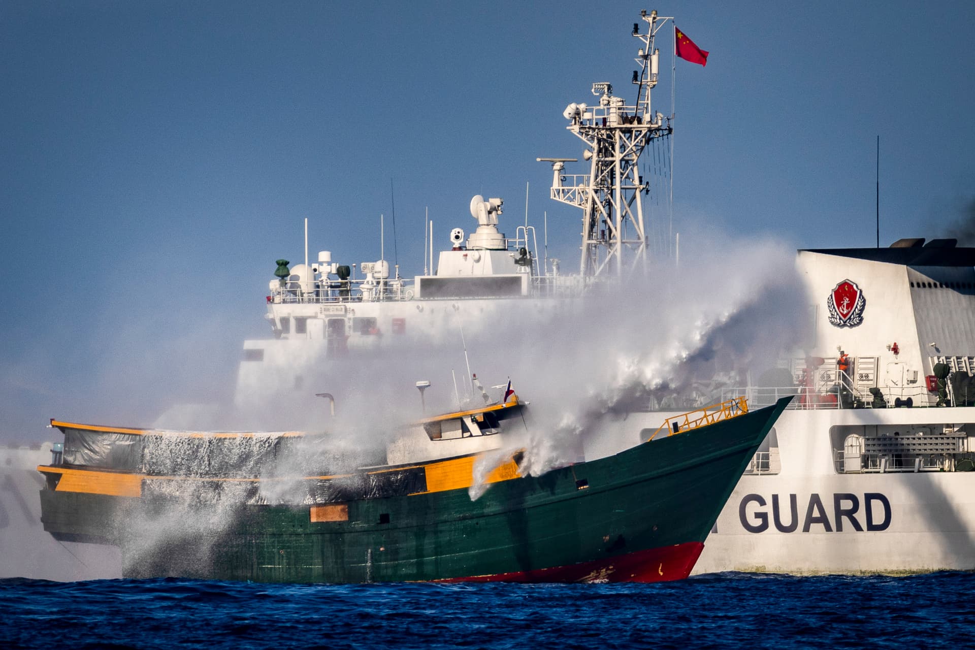A Chinese Coast Guard ship fires a water cannon at Unaizah, a Philippine Navy chartered vessel, conducting a routine resupply mission to troops stationed at Second Thomas Shoal in the South China Sea on March 5, 2024. (Ezra Acayan/Getty Images)