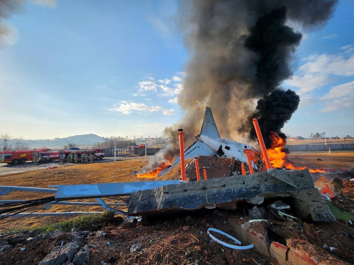 Firefighters carry out extinguishing operations on an aircraft which drove off runaway at Muan International Airport in Muan, South Jeolla Province, South Korea, on Dec. 29, 2024. (Yonhap via Reuters)