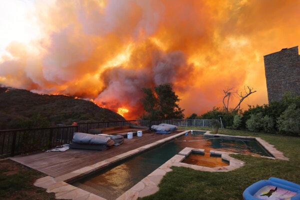 A brush fire burns near homes in Pacific Palisades, Calif., on Jan. 7, 2025. (David Swanson/AFP via Getty Images)