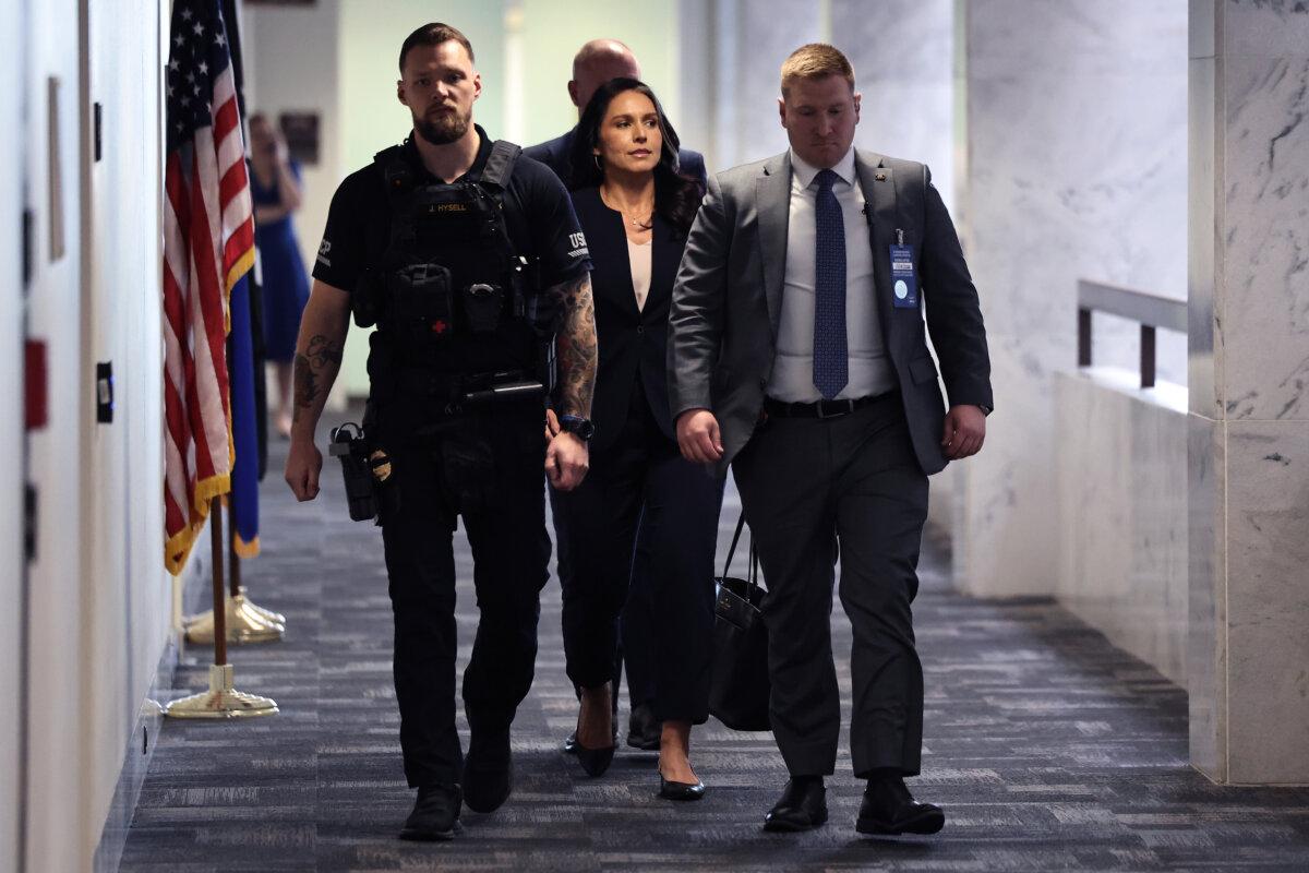 Former U.S. Rep. Tulsi Gabbard from Hawaii is escorted by police as she moves between meetings with senators in the Hart Senate Office Building on Capitol Hill in Washington on Dec. 18, 2024. (Chip Somodevilla/Getty Images)