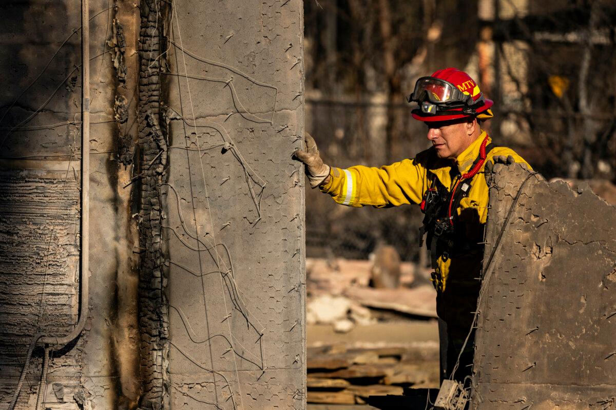 A firefighter walks among the remains of a house reduced to rubble by the Eaton Fire during search and rescue operations in Altadena, Calif., on Jan. 13, 2025. (Etienne Laurent/AFP via Getty Images)