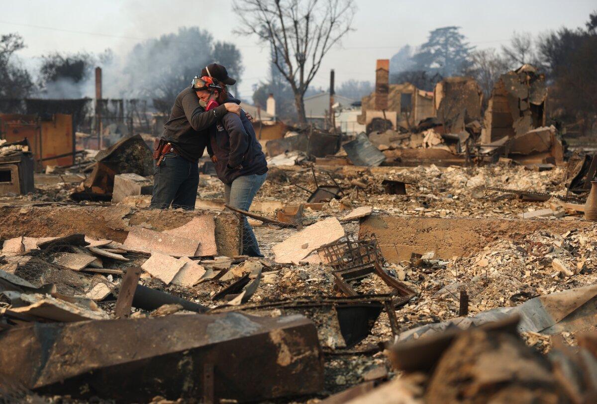 Khaled Fouad (L) and Mimi Laine (R) embrace as they inspect a family member's property that was destroyed by Eaton Fire in Altadena, Calif., on Jan. 9, 2025. (Justin Sullivan/Getty Images)