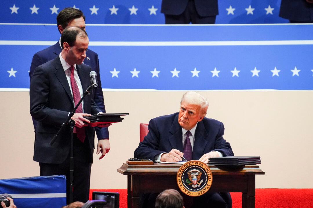 U.S. President Donald Trump signs executive orders at Capital One Arena in Washington on Jan. 20, 2025. (Madalina Vasiliu/The Epoch Times)