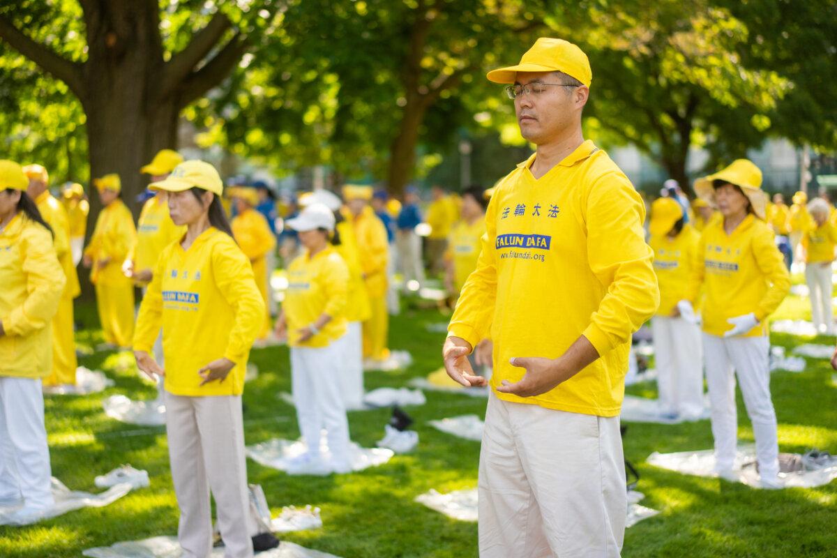 Falun Gong practitioners demonstrate meditative exercises during an event held at Queen's Park in Toronto on July 20, 2024. The event marks the 25th anniversary of the Chinese regime's persecution of Falun Gong. (Evan Ning/The Epoch Times)