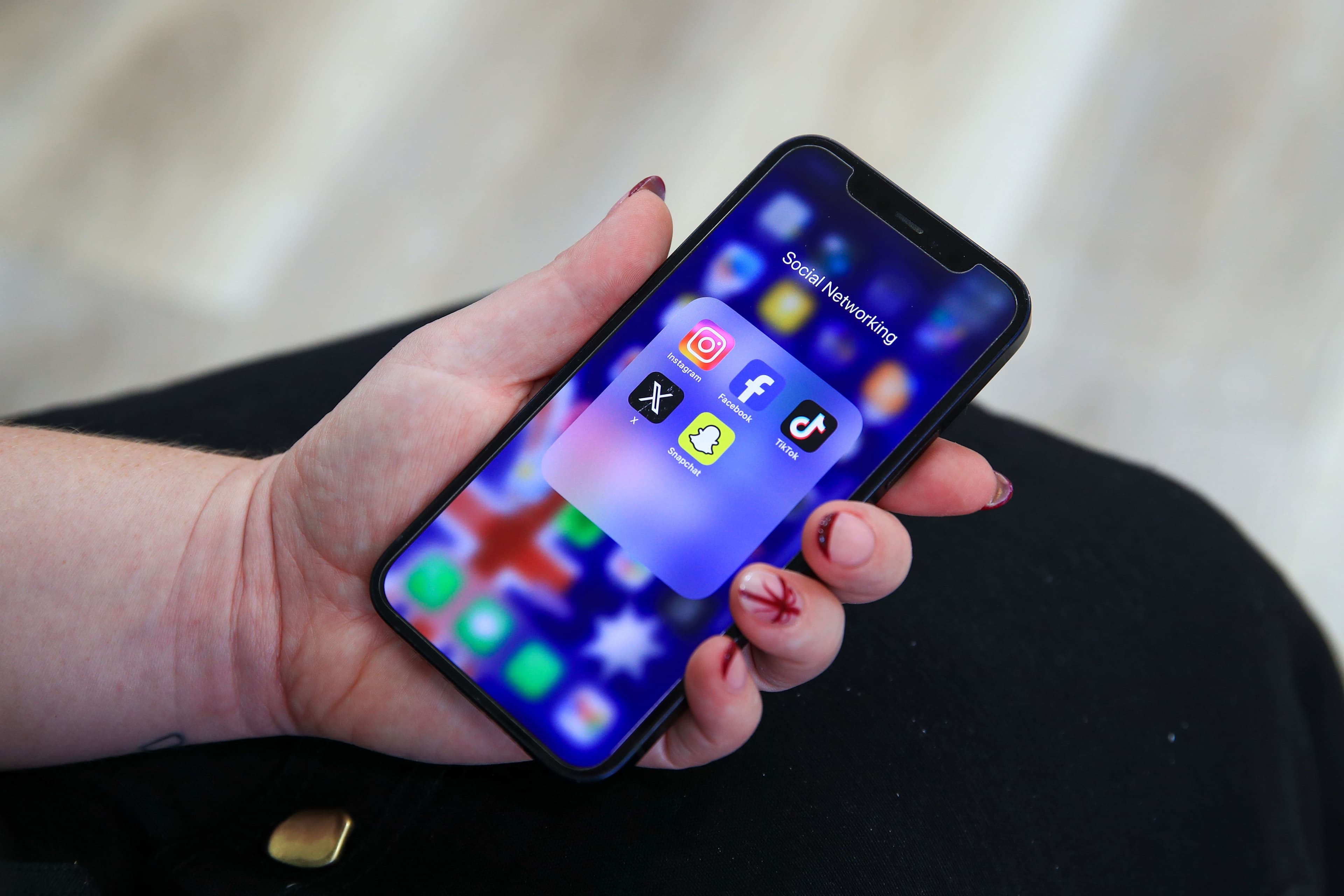 Social media apps are displayed on a phone screen in a photo illustration on Dec. 1, 2024. (Roni Bintang/Getty Images)