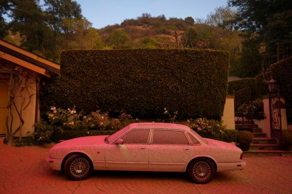 A vehicle is covered in fire retardant while crews battle the Palisades Fire in Mandeville Canyon in Los Angeles on Jan. 11, 2025. (Eric Thayer/AP Photo)