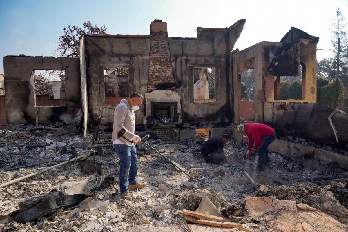 Homeowner David Marquez (L) holds a metal detector as his father, Juan Pablo Alvarado (R) and a friend look for the remains of gold jewelry and other silver items inside the walls of their multi-generational home in the aftermath of the Eaton Fire in Altadena, Calif., on Jan. 19, 2025. (Damian Dovarganes/AP Photo)