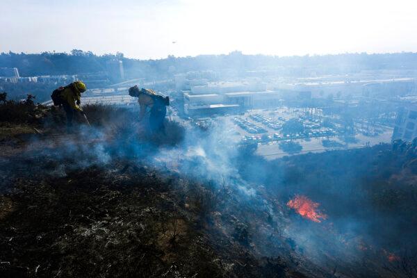 San Diego firefighters knock down a small brush along a hillside over the Mission Valley Shopping Mall in San Diego on Jan. 21, 2025. (Gregory Bull/AP Photo)