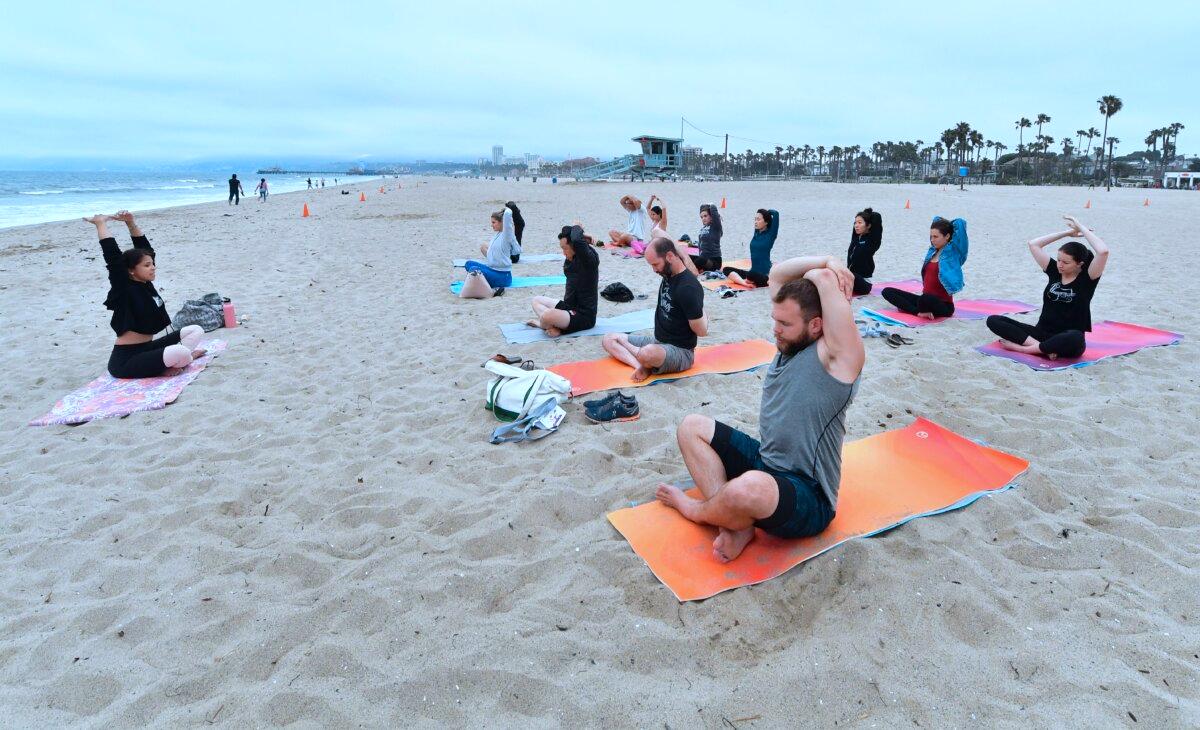 Yoga instructor Vee Gomez leads a beach yoga class on an overcast evening to celebrate International Yoga Day, which is also the summer solstice, at Santa Monica beach on June 21, 2018. (Frederic J. Brown/AFP via Getty Images)