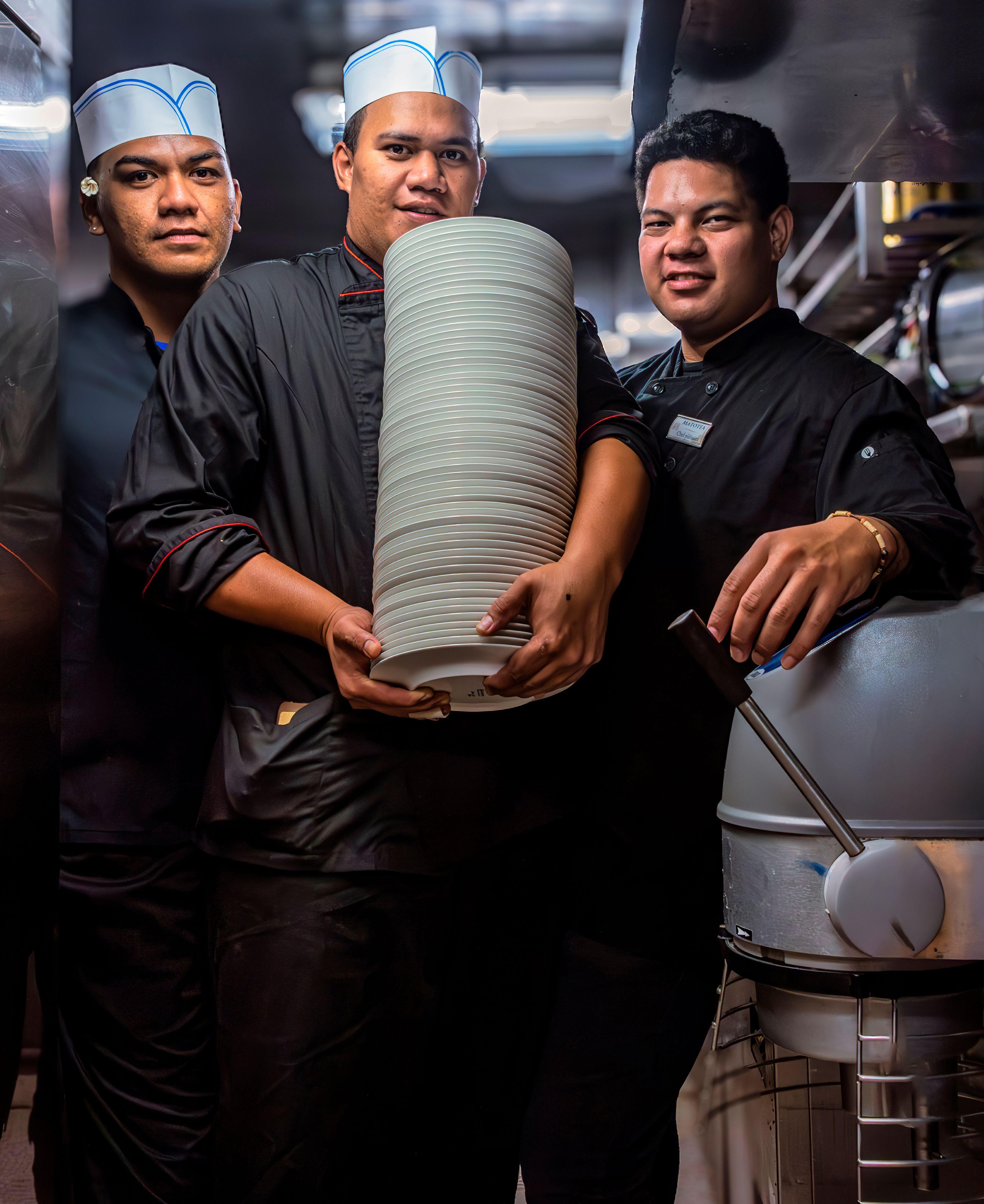 Tahitian kitchen assistants (L–R) Nakotea Vehiatua (23), Etera Teahui (27), and Tamatrona Teheiura (27) stand in the galley. (Maria Coulson)