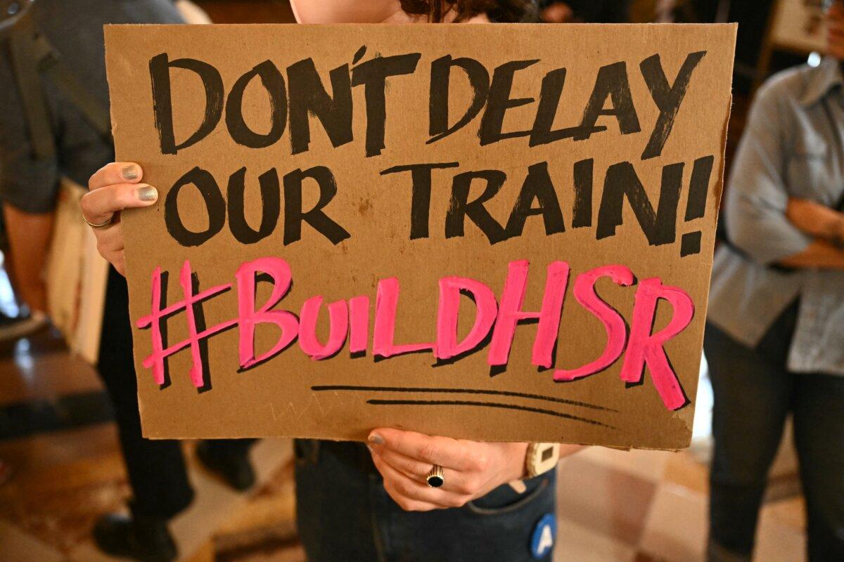 Protesters hold signs at Union Station in downtown Los Angeles on Feb. 20, 2025. (Patrick T. Fallon/AFP via Getty Images)