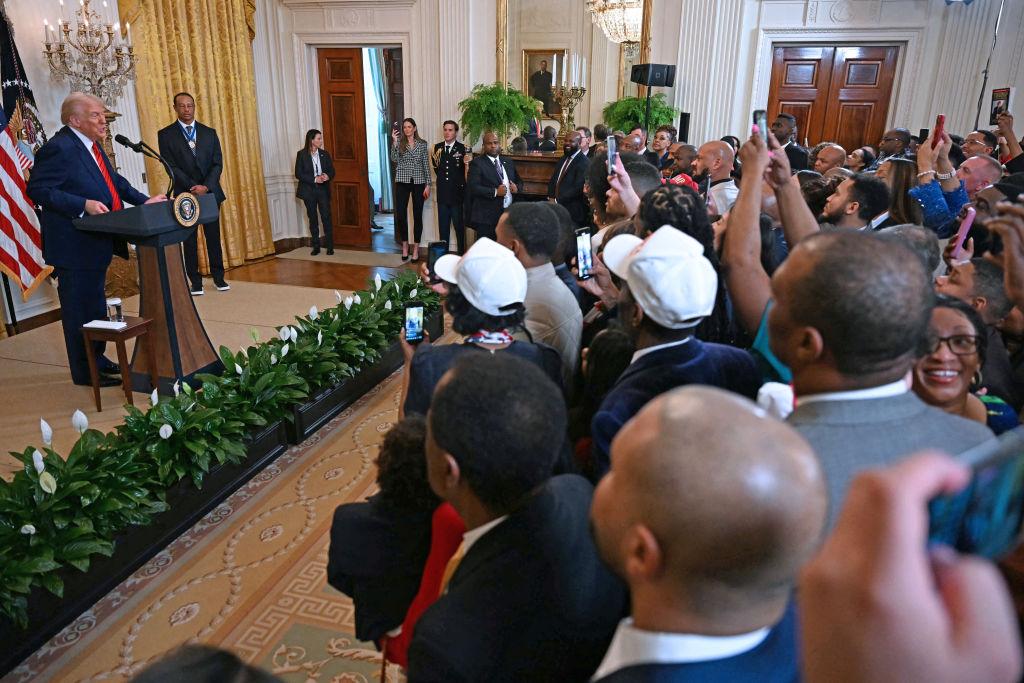 President Donald Trump speaks alongside golfer Tiger Woods during a reception for Black History Month in the East Room of the White House on Feb. 20, 2025. (Jim Watson/AFP via Getty Images)