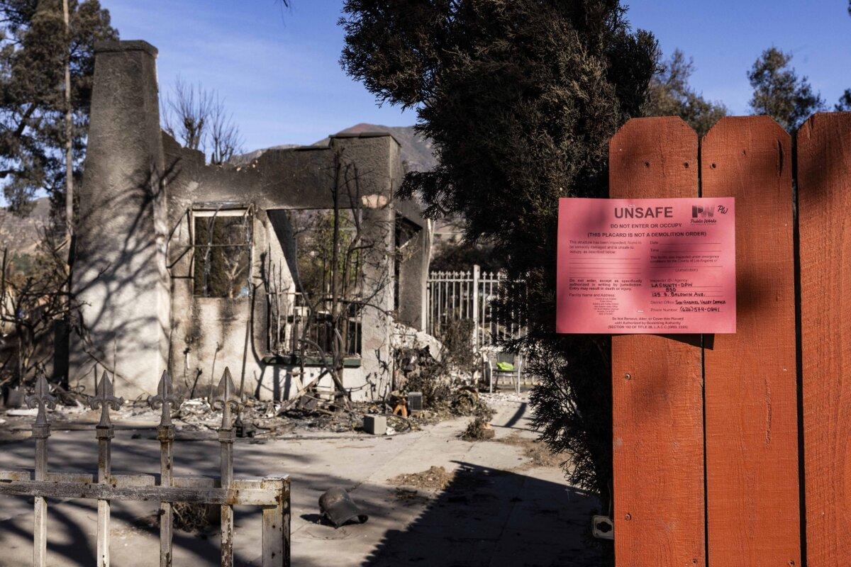 A sign saying "unsafe" outside destroyed homes on the streets of Altadena, Calif., on Jan. 24, 2025. (John Fredricks/The Epoch Times)