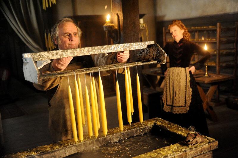Edward Haddington (Sylvester McCoy) and Bea Haddington (Lesley Manville) make candles, in “The Christmas Candle.” (Pinewood Studios/MovieStillsDB)