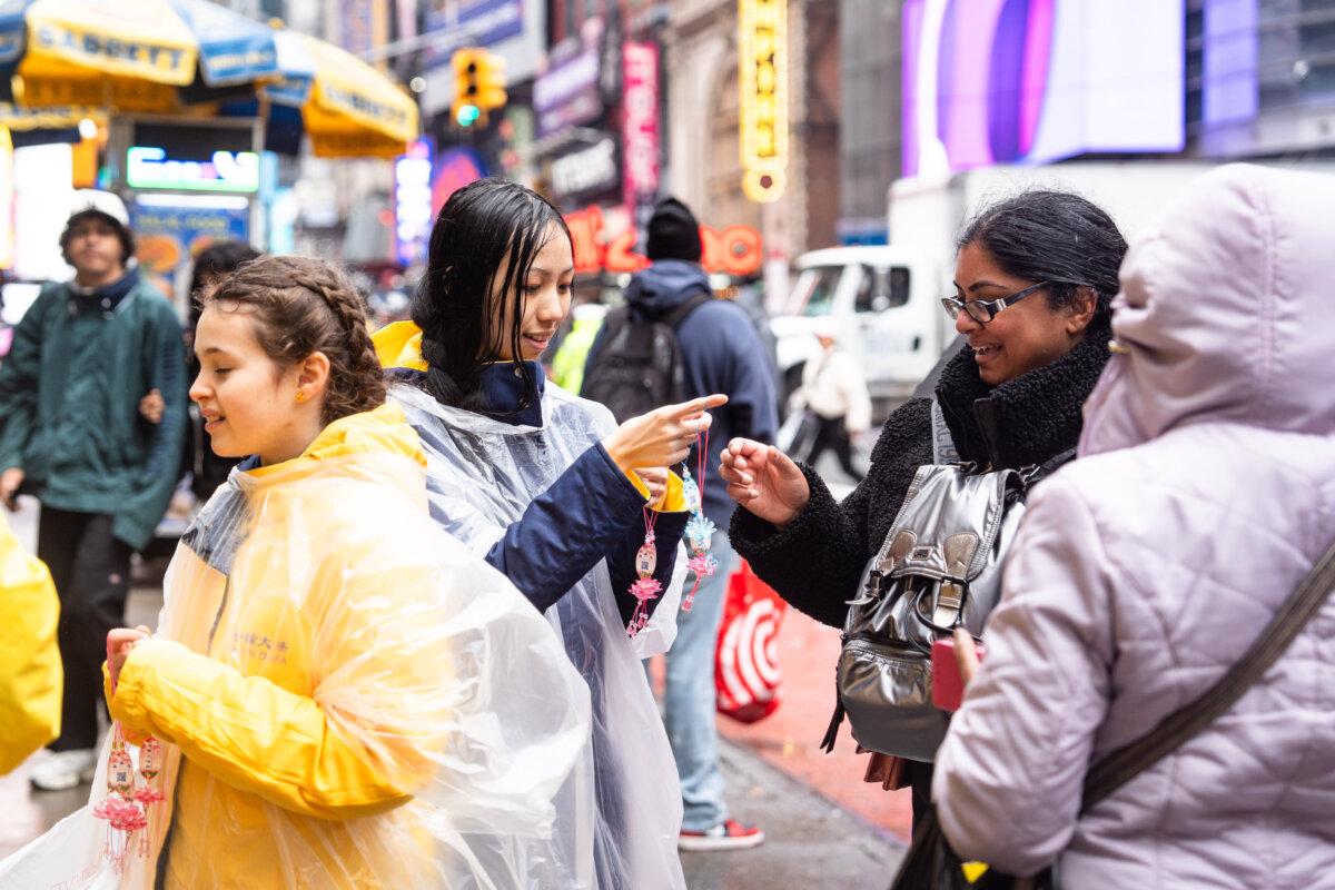 Falun Gong practitioners talk to onlookers during the parade to celebrate World Falun Dafa Day in New York City on May 9, 2025. (Samira Bouaou/The Epoch Times)