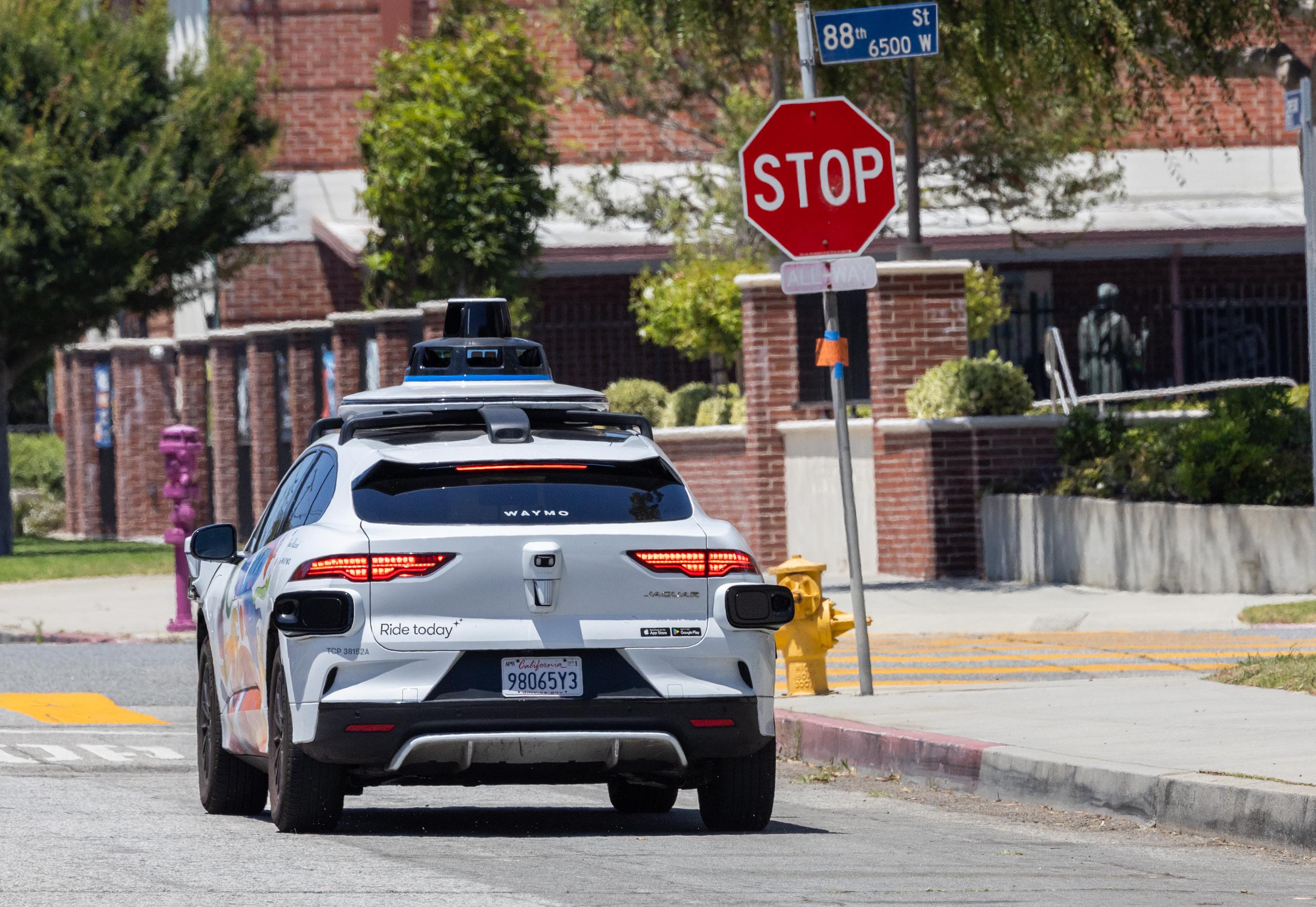 A self-driving Waymo vehicle awaits passengers in Los Angeles on July 1, 2025.  (John Fredricks/The Epoch Times)
