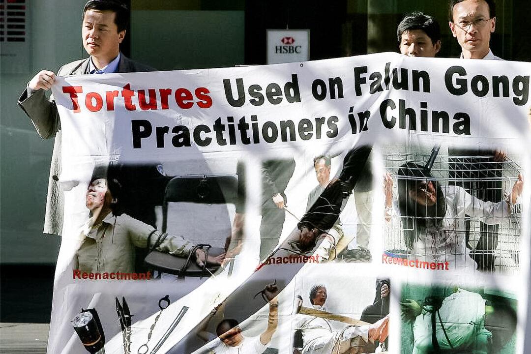 Supporters of Falun Gong display a banner showing torture re-enactments near Chinatown in Sydney on July 20, 2005. (Greg Wood/AFP/Getty Images)