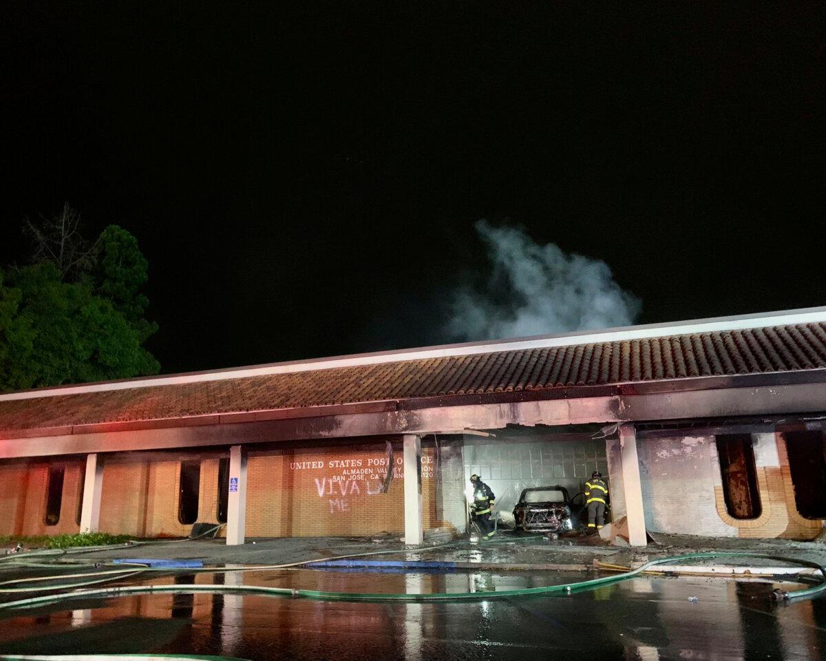 Firefighters respond to a fire burning after a car crashed into the Post Office in San Jose, Calif., early on July 20, 2025. (San Jose Fire Department via AP)