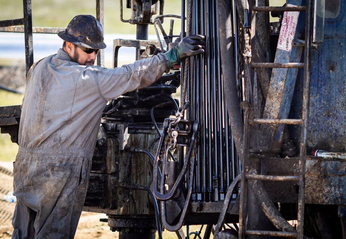 Oil specialists keep pumps in operation outside of Bakersfield, Calif., on March 21, 2025. (John Fredricks/The Epoch Times)