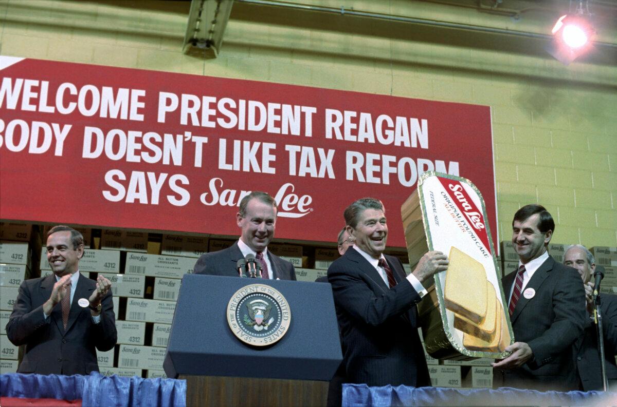 President Reagan holding up large coffee cake after remarks at Sara Lee Kitchens in Deerfield, Ill. National Archives. (Public Domain)