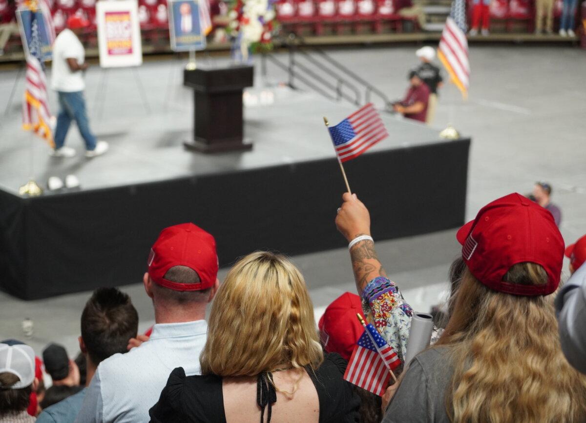 Charlie Kirk supporters wave American flags during a vigil honoring the fallen conservative youth leader in Tempe, Ariz., on Sept. 15, 2025. (Allan Stein/The Epoch Times)