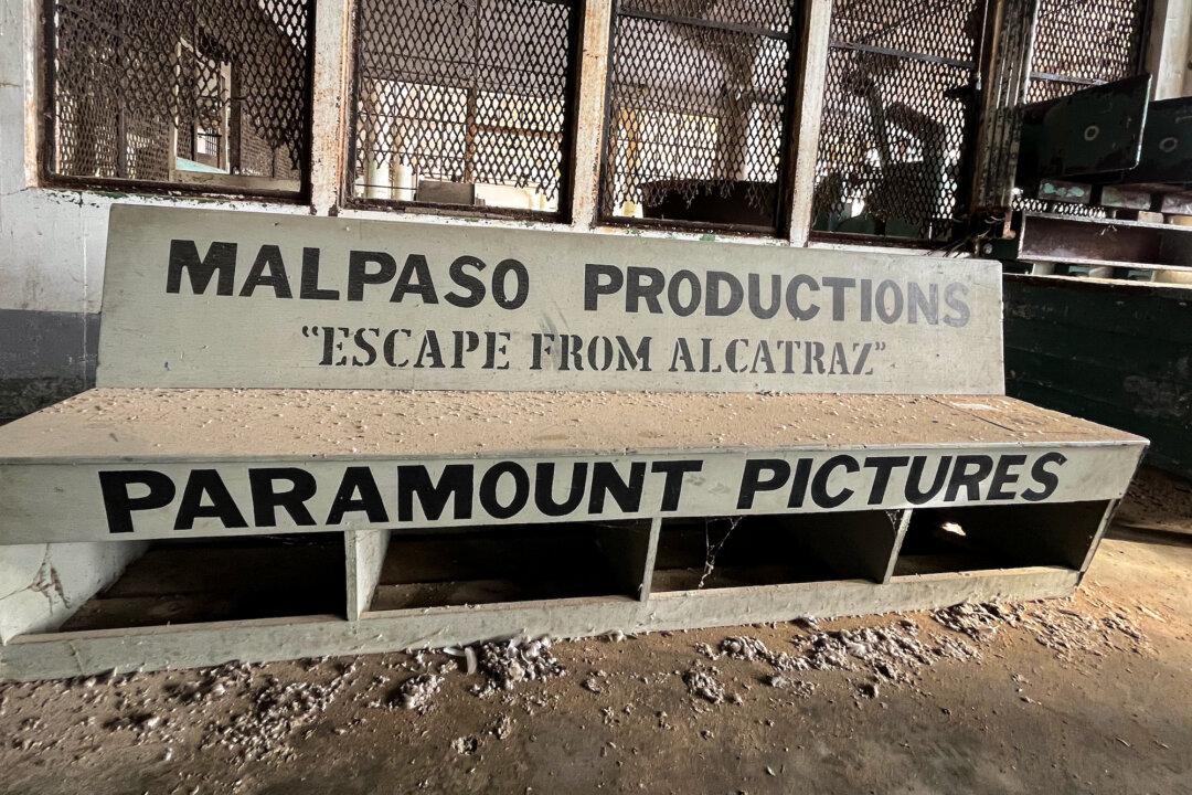 (Top L) Visitors tour the cramped prison cells on Alcatraz Island in the San Francisco Bay on Sept. 9, 2025. (Top R) The prison infirmary at the former Alcatraz federal penitentiary on Sept. 9, 2025. (Bottom L) A visitor experiences what it was like to be inside a prison cell at the Alcatraz federal penitentiary on Sept. 9, 2025. (Bottom R) The bench used in the production of the 1979 movie “Escape From Alcatraz,” featuring Clint Eastwood, remains in the main cell building at Alcatraz Island on Sept. 9, 2025. (Allan Stein/The Epoch Times)