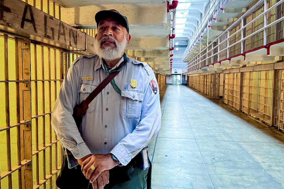 A National Parks Service (NPS) employee answers questions from visitors at the former federal prison on Alcatraz Island on Sept. 9, 2025. The NPS took control of the island in 1972, nearly a decade after the prison closed, and reopened it for recreation. (Allan Stein/The Epoch Times)
