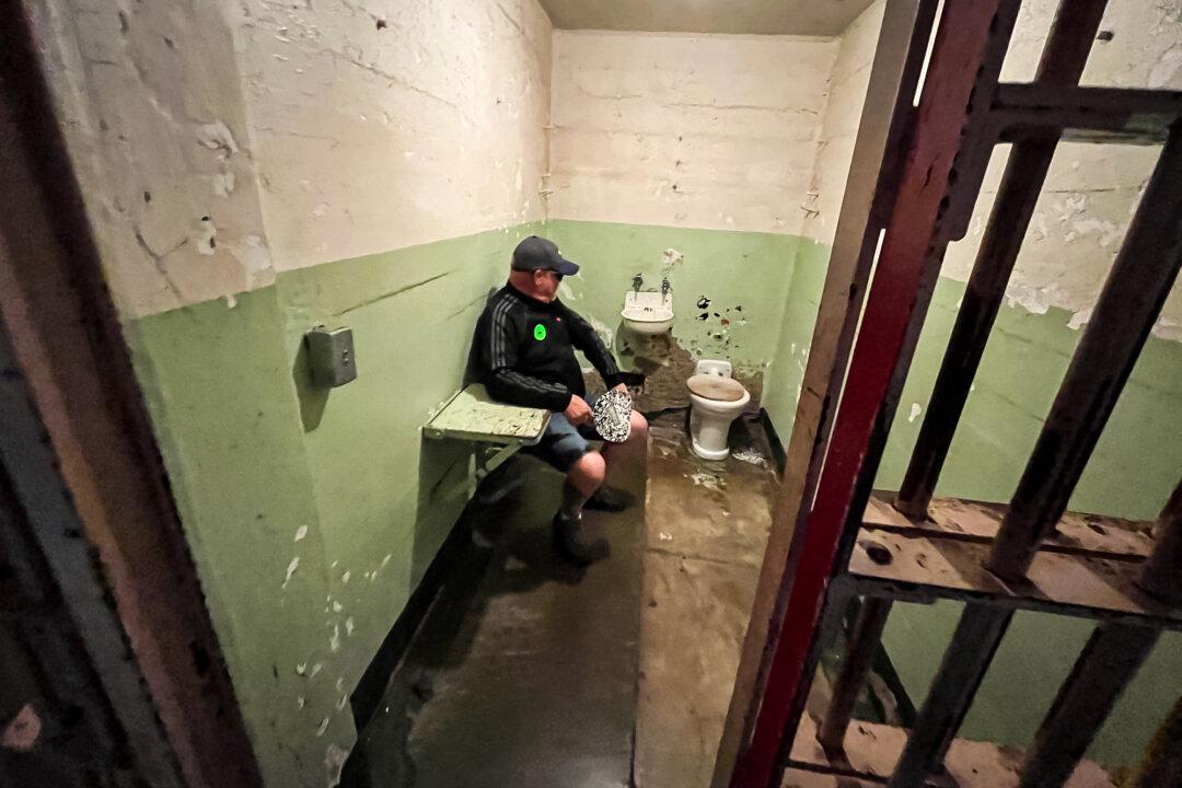 (Top L) Visitors tour the cramped prison cells on Alcatraz Island in the San Francisco Bay on Sept. 9, 2025. (Top R) The prison infirmary at the former Alcatraz federal penitentiary on Sept. 9, 2025. (Bottom L) A visitor experiences what it was like to be inside a prison cell at the Alcatraz federal penitentiary on Sept. 9, 2025. (Bottom R) The bench used in the production of the 1979 movie “Escape From Alcatraz,” featuring Clint Eastwood, remains in the main cell building at Alcatraz Island on Sept. 9, 2025. (Allan Stein/The Epoch Times)