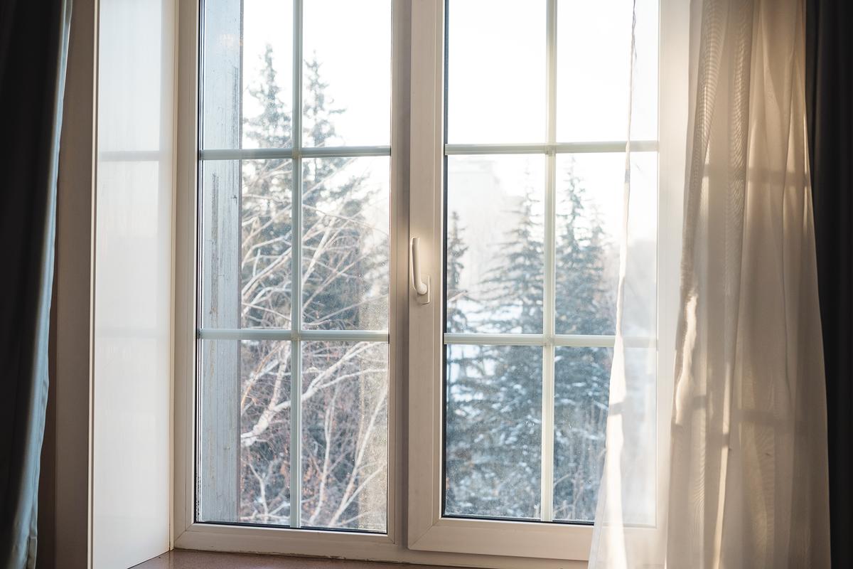 Opening curtains during the day lets sunlight naturally warm the room. (SasinParaksa/Getty Images)