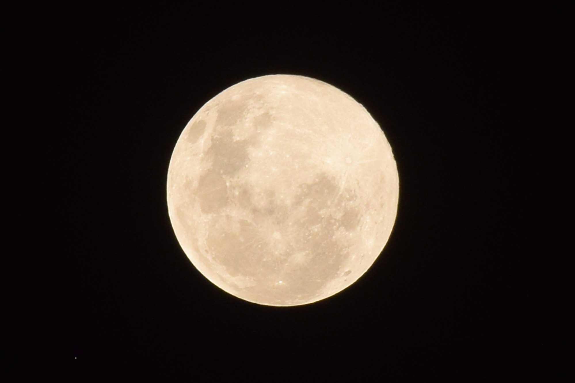 A full moon glows a pale yellow, calling to mind autumn leaves. (Shutterstock/Photonetwork21)