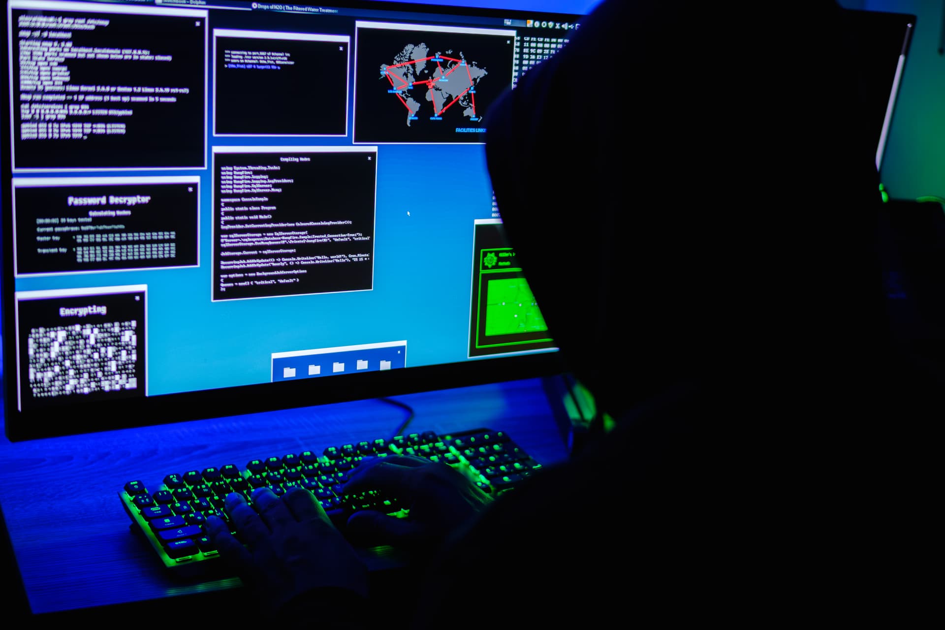 In this photo illustration, a hooded man types on a computer keyboard on May 13, 2025. (Oleksii Pydsosonnii/The Epoch Times)