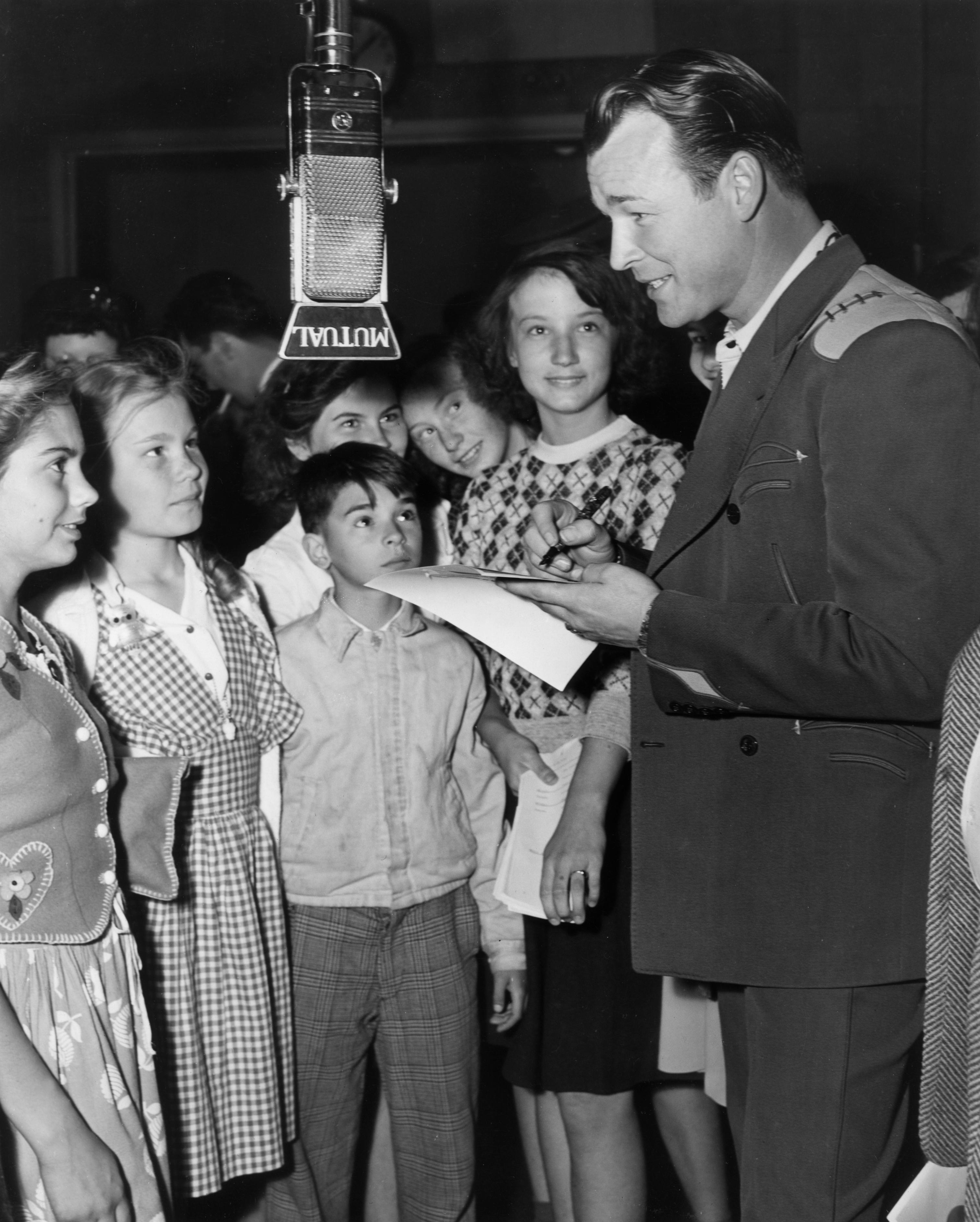 Roy Rogers signs autographs for a group of doting fans inside the radio studio after taping his weekly show, circa 1945. (Hulton Archive/Getty Images)