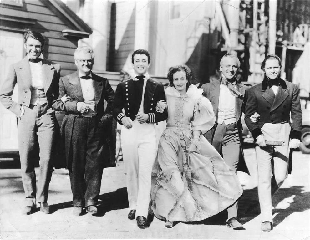 (L–R) James Stewart, Lionel Barrymore, Robert Taylor, Joan Crawford, Melvyn Douglas, and Franchot Tone on the set of “The Gorgeous Hussy.” (Metro-Goldwyn-Mayer)