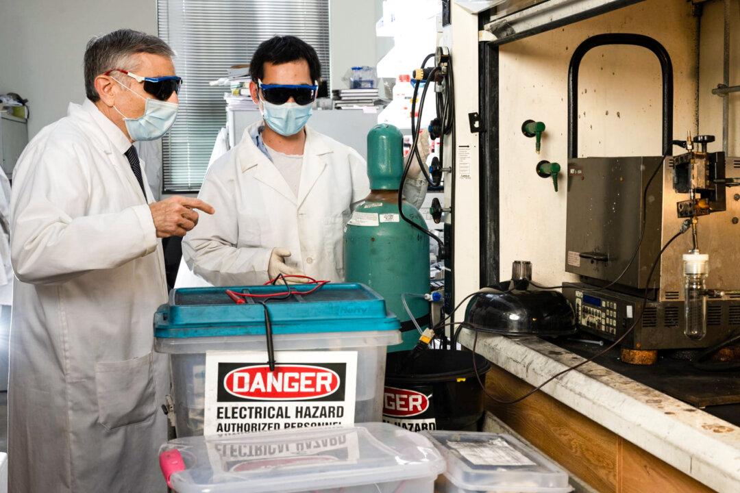 Rice University chemist James Tour (L) and postdoctoral research associate Bing Deng (R) prepare to “flash” electronic waste to recover its valuable metals for recycling. The lab’s process, first developed to turn waste food and other carbon sources into graphene, has been adapted to recover other materials. (Jeff Fitlow/Rice University)