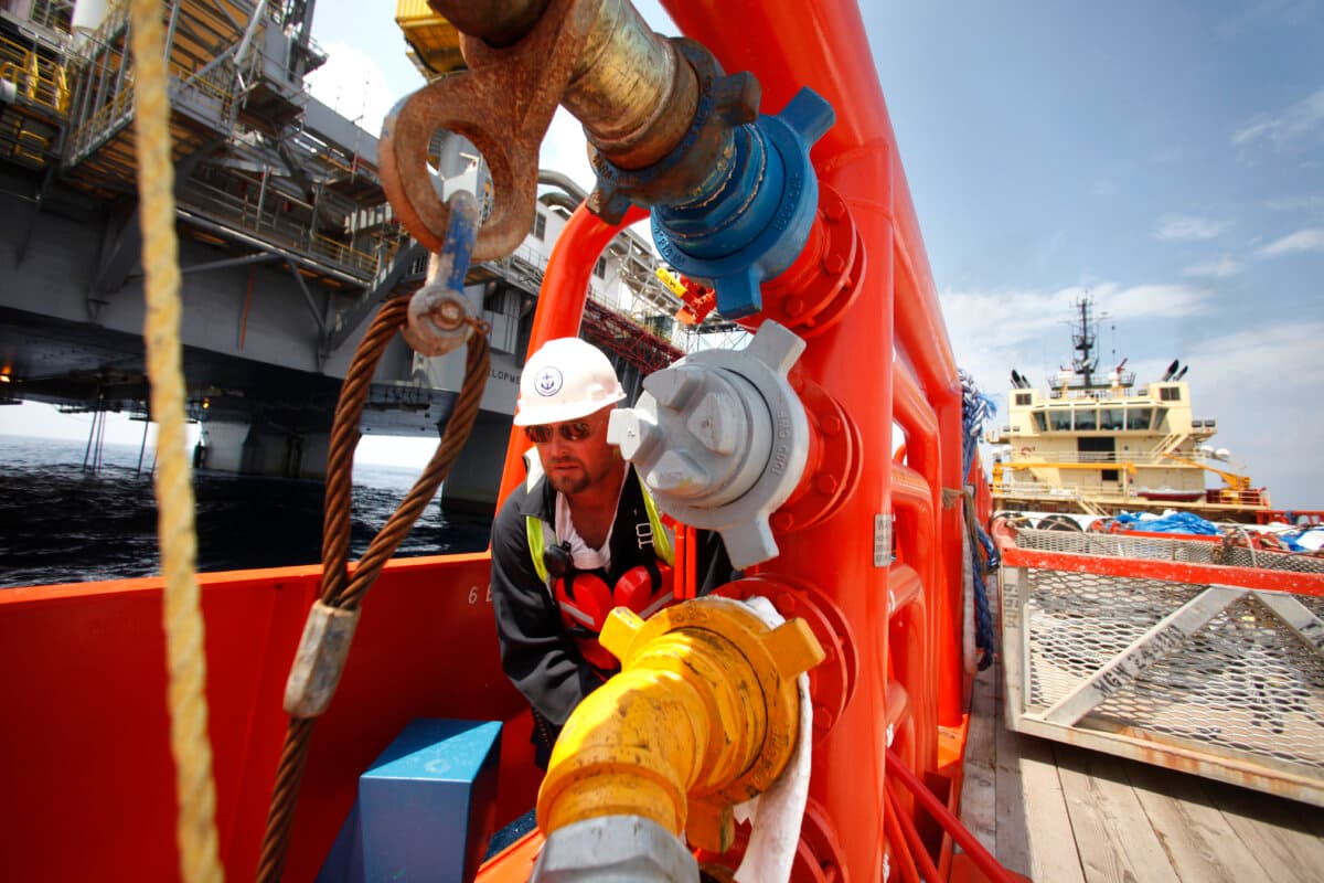 A crew member of a supply vessel turns a valve to transfer fuel to the Development Driller III drilling rig off the coast of Louisiana in the Gulf of America, on May 11, 2010. (Gerald Herbert-pool/Getty Images)