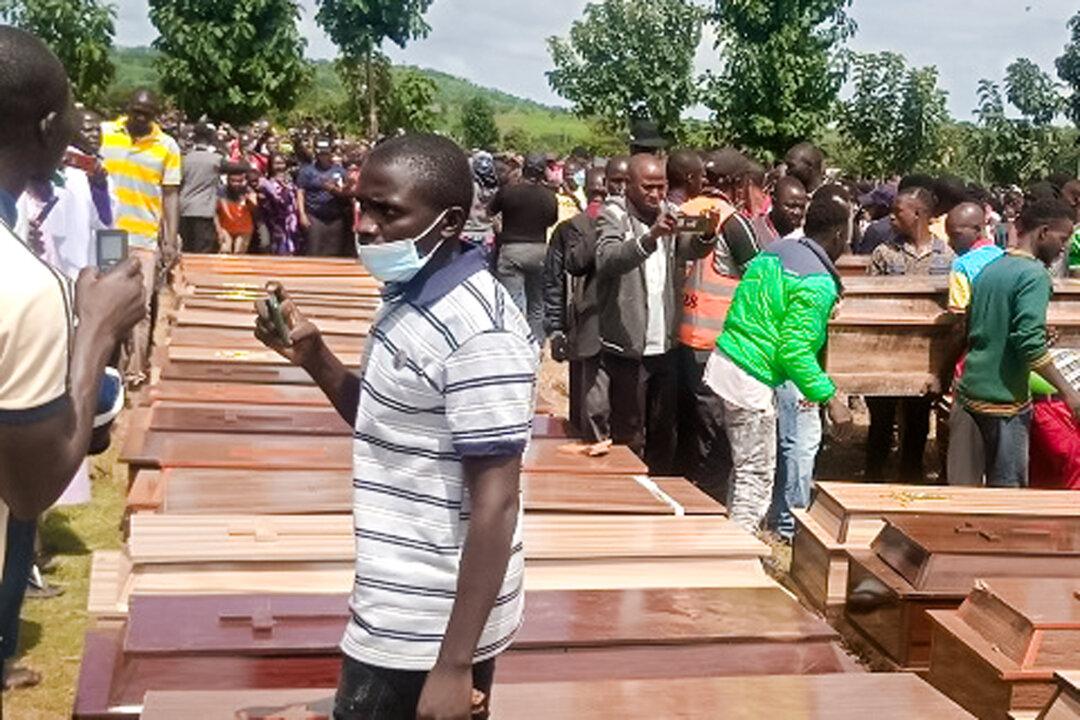 Caskets holding the bodies of 38 Christian villagers killed by armed Fulani Muslim militants are arranged for a funeral Mass at Government Secondary School in Mallagun, Nigeria, on Sept. 30, 2021. (Luka Binniyat/The Epoch Times)
