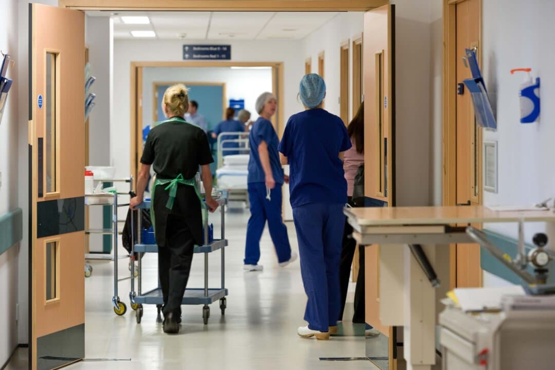 Health care workers walk down a hospital hallway in this file image. (Alamy/PA)