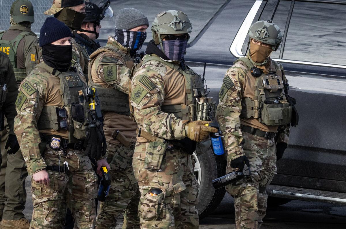 Immigration and Customs Enforcement (ICE) agents confront protestors in front of the Bishop Henry Whipple Federal Building in Minneapolis, Minn., on Jan. 12, 2026. (John Fredricks/The Epoch Times)