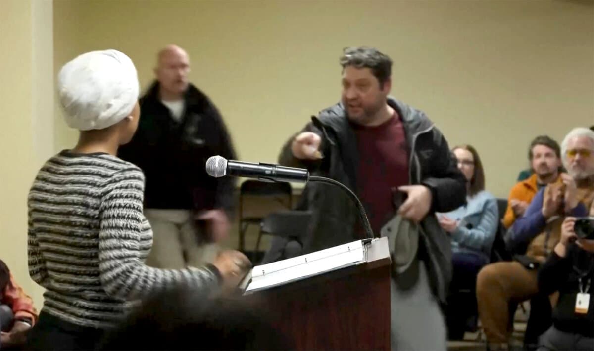 A man shouts at Rep. Ilhan Omar (D-Minn.) after spraying her during a town hall meeting in Minneapolis on Jan. 27, 2026, in a still image from video. (Maria Alejandra Cardona/Reuters)
