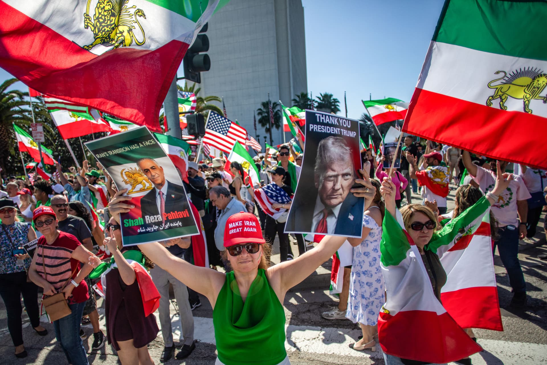 A woman holds pictures of Reza Pahlavi and U.S. President Donald Trump as members of the Iranian community celebrate in front of the Federal Building in Los Angeles on Feb. 28, 2026. (Apu Gomes/AFP via Getty Images)