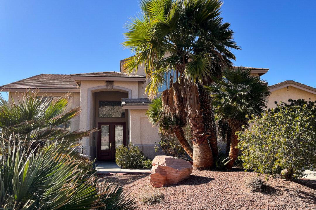 (Left) The property at 979 Sugar Springs Drive in Las Vegas on Feb. 3. 2026. Law enforcement raided the home on Jan. 31, 2026, after receiving a tip about suspcious activity involving unknown materials. (Right) Electrical boxes on the side of a garage where law enforcement discovered a freezer and multiple refrigerators in a suspected illegal biolab. (Allan Stein/The Epoch Times)